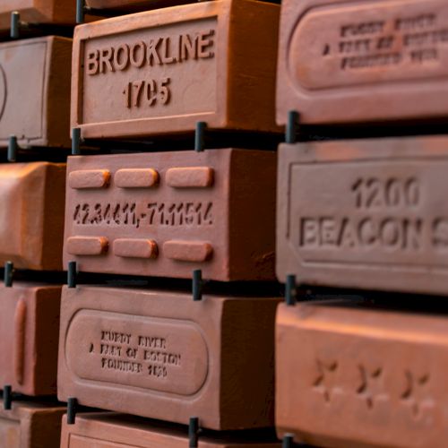 A close-up of a labeled wooden display showing &ldquo;BROOKLINE&rdquo; with &ldquo;1905,&rdquo; surrounded by other numbered nameplates.