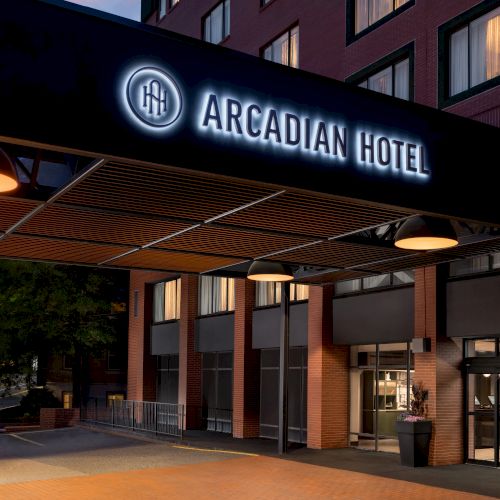 Night view of the Arcadian Hotel entrance sign on a brick building.